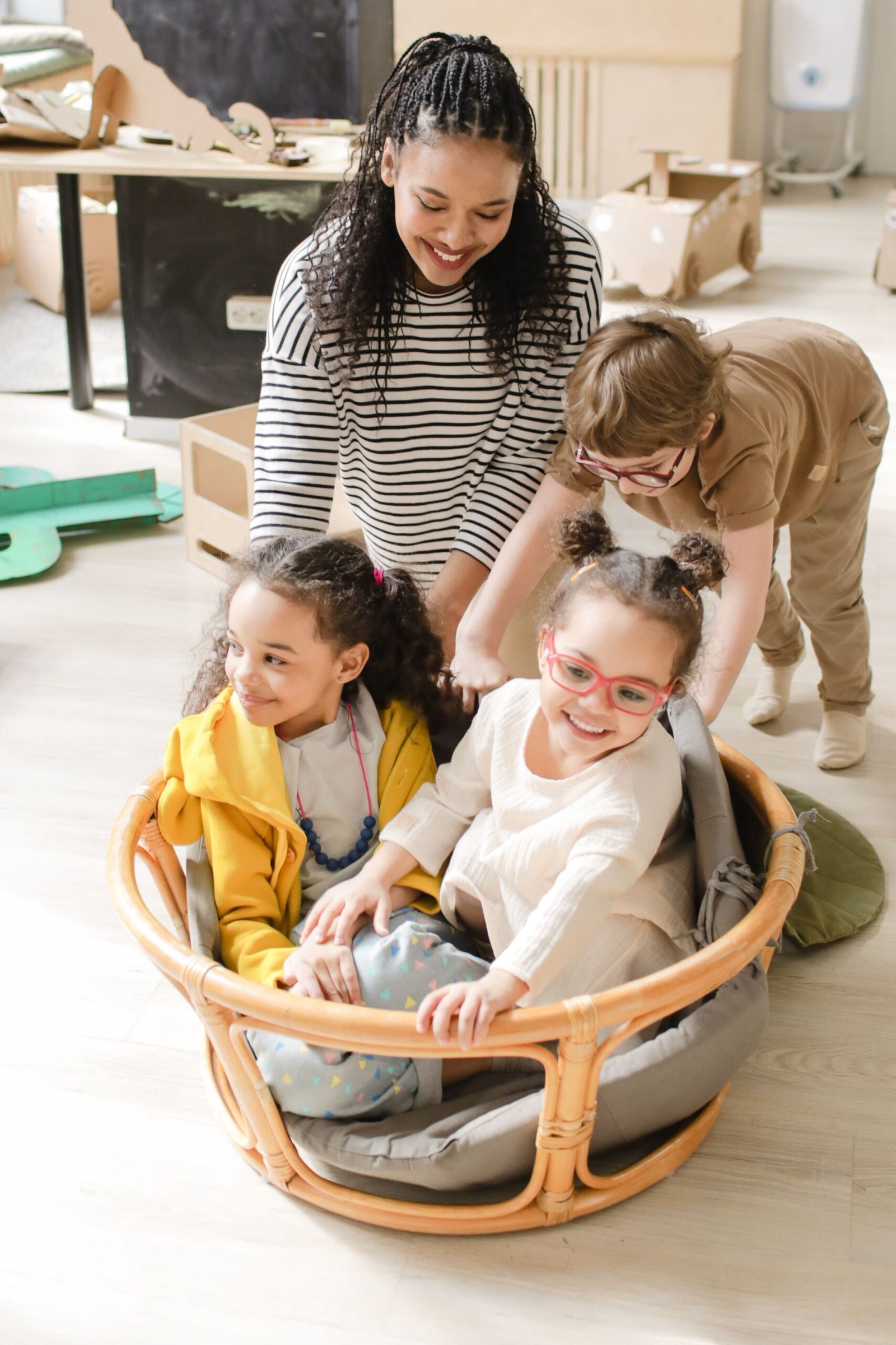 Happy preschool children playing together indoors with their teacher, enjoying a fun and interactive activity.